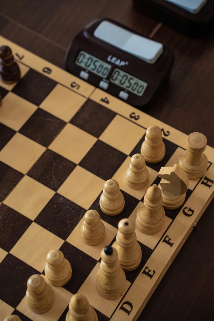 Chess board close-up view with pieces and a digital timer in a strategic setup.