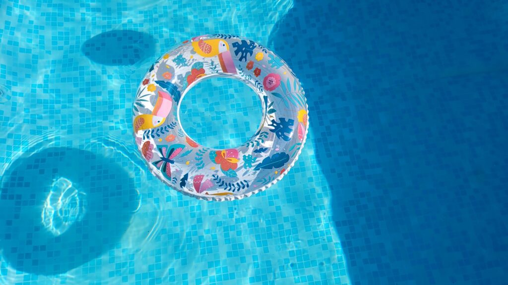 Vibrant inflatable swim ring floating in a sunlit pool, perfect for summer fun.