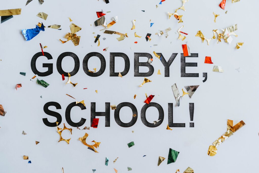 Colorful confetti surrounds a goodbye school message, celebrating graduation.
